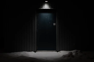 an open door in a dark room with snow on the ground