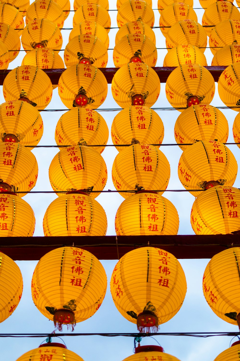 a bunch of yellow lanterns hanging from a wire