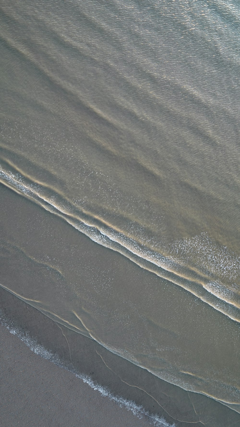 une personne sur une planche de surf au sommet d’une plage couverte de vagues