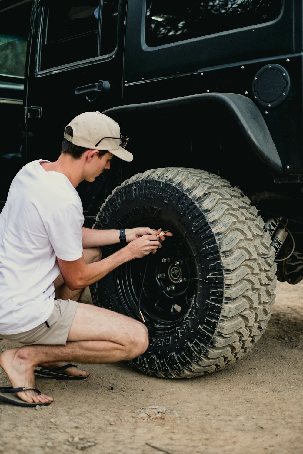 a man fixing a tire on a jeep