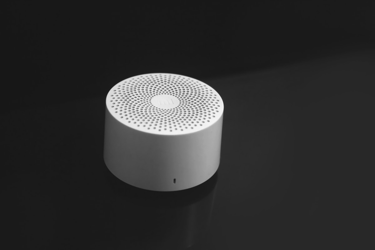 A white speaker sitting on top of a black table