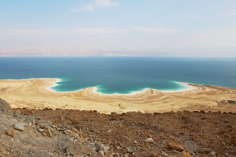 a large body of water sitting on top of a rocky hillside