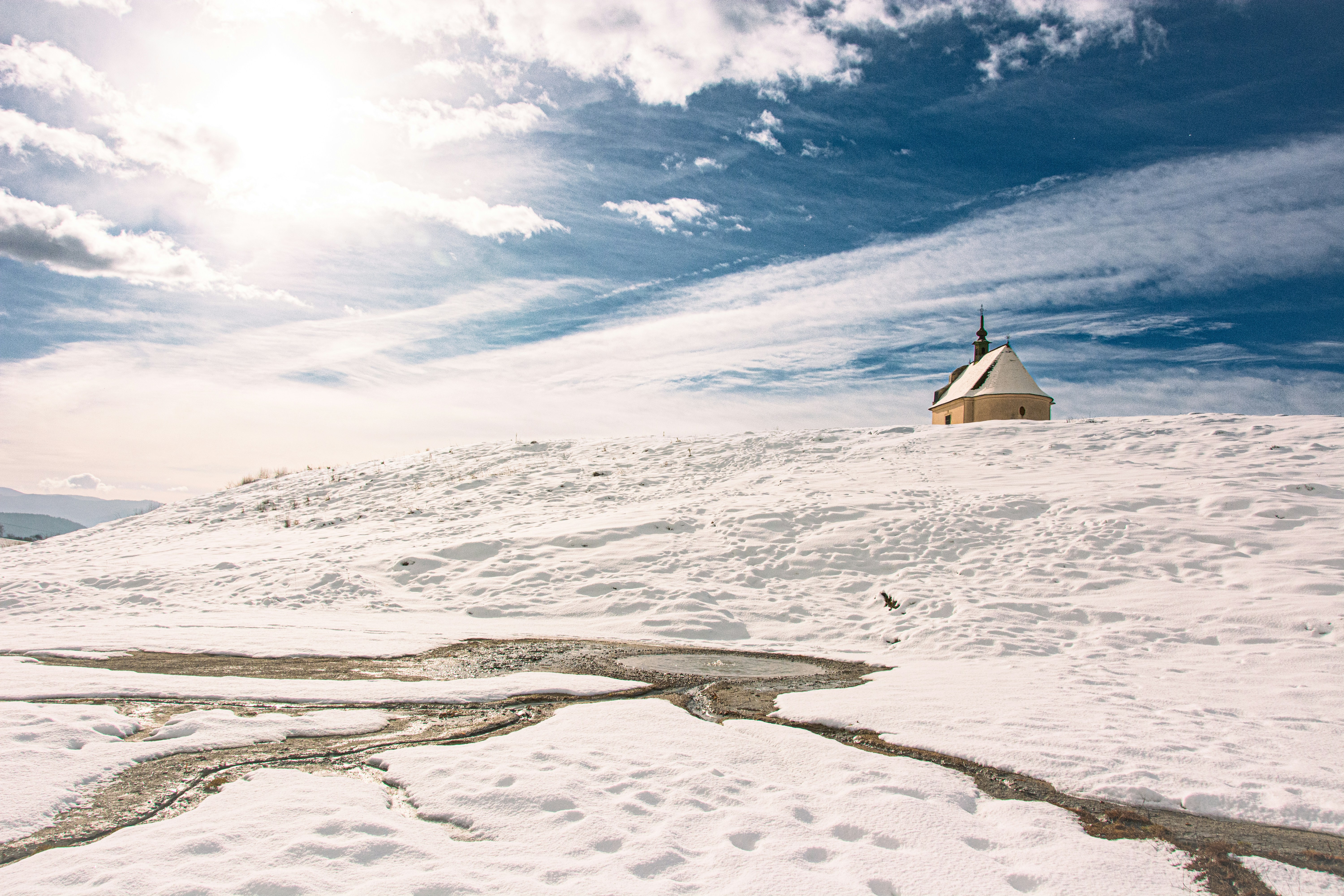 ein schneebedeckter Hügel mit einem kleinen Haus darauf