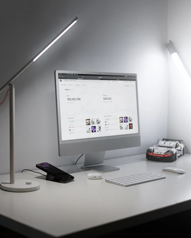 A sleek, modern office workspace with automotive testing equipment visible through a glass partition.