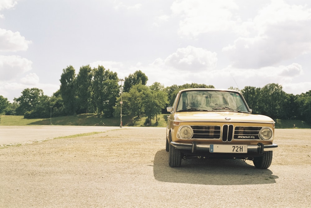 a car parked in a parking lot with trees in the background