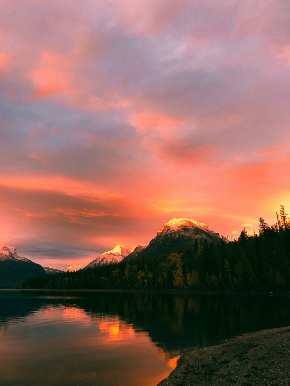 Una hermosa puesta de sol sobre un lago con montañas al fondo
