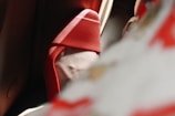 A close-up image showcasing the elegant curve of a high-heeled red shoe. Soft shadows and light create a dramatic and stylish atmosphere, with parts of the shoe blurred in the foreground, suggesting a sense of movement or depth.