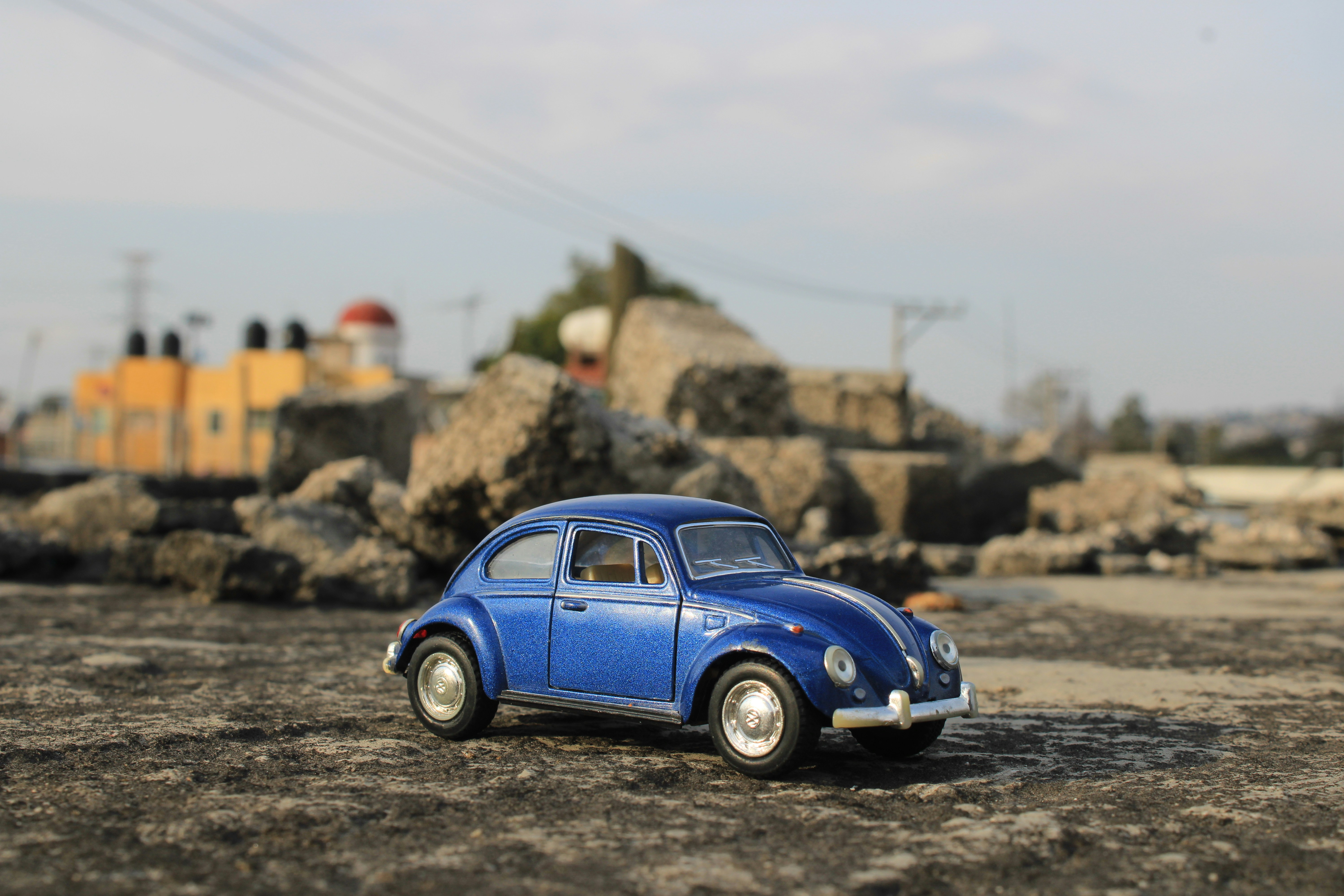 a blue toy car sitting on top of a dirt field