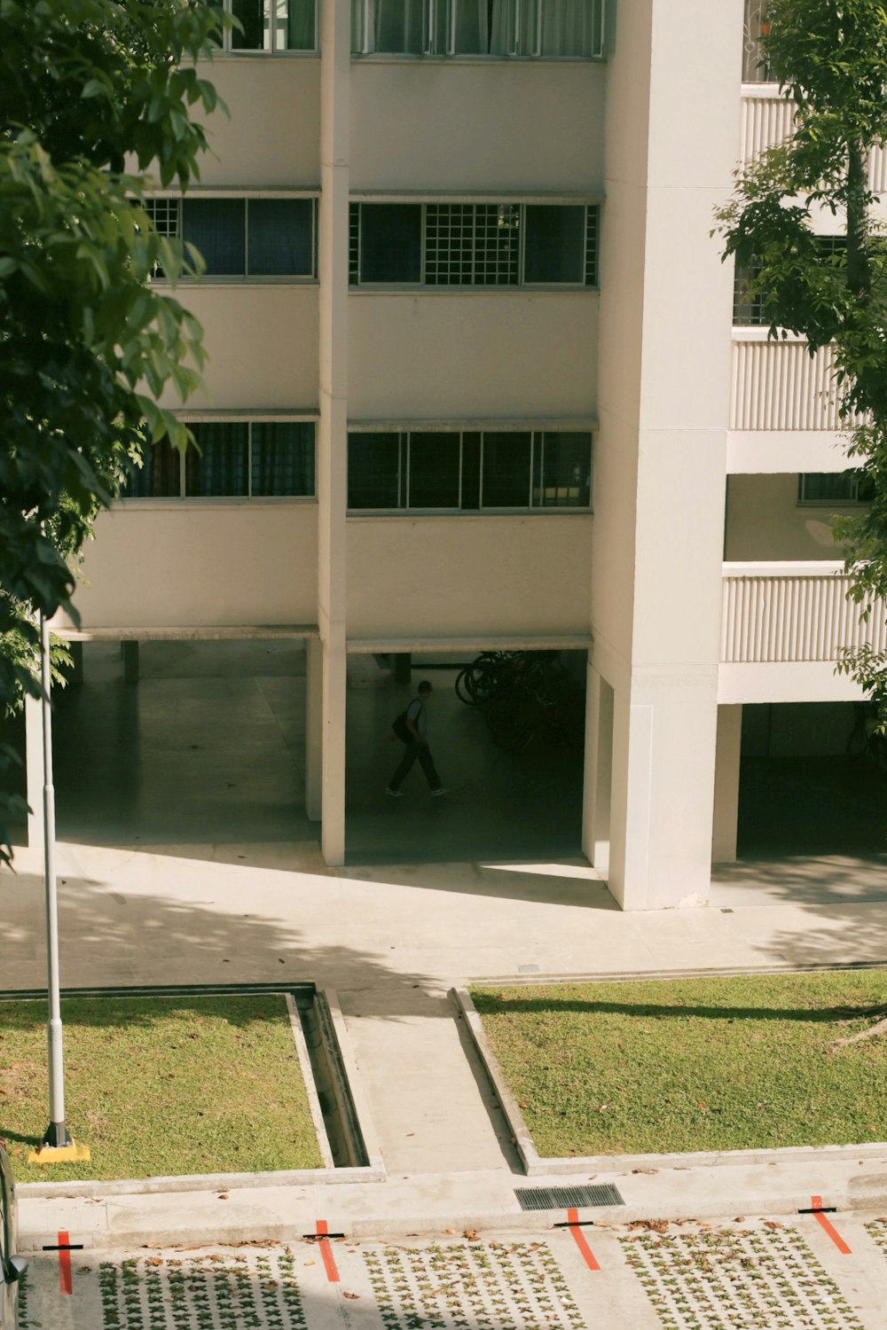 a tall white building sitting next to a lush green park