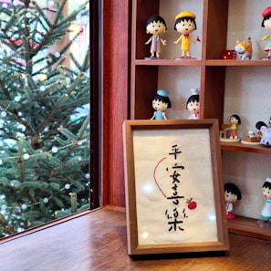 A collection of unique small ornaments displayed on a wooden shelf.