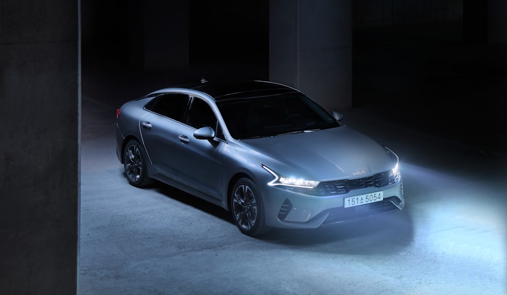 a silver car parked in a dark room