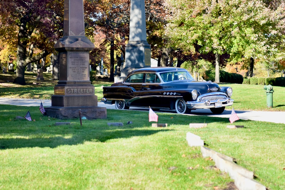 a classic car parked in front of a monument