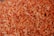 A large pile of dried shrimp with a vibrant orange color, showcasing a texture that appears slightly crispy. The shrimp are small in size and densely packed together, covering the entire image frame.