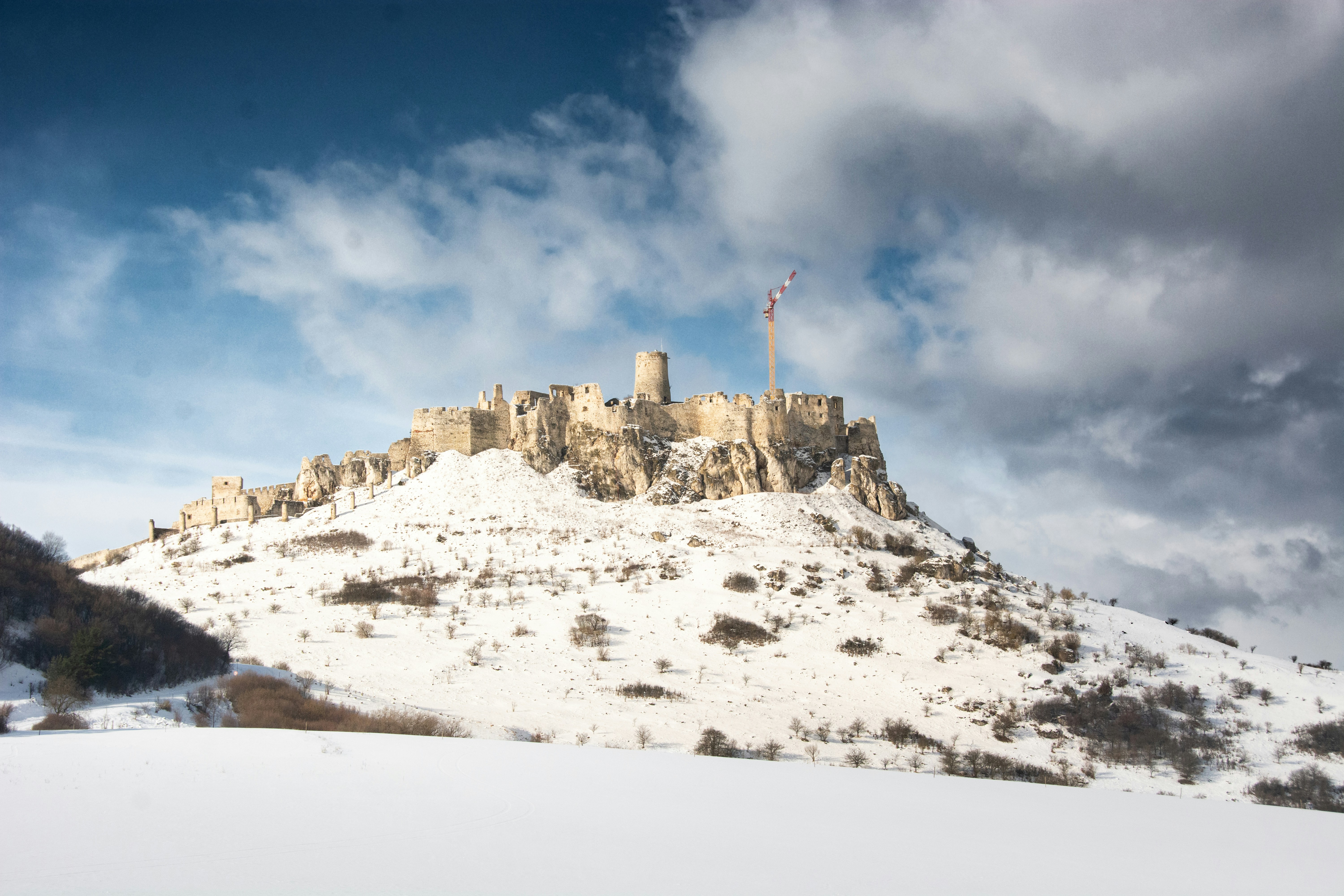 ein schneebedeckter Berg mit einer Burg auf der Spitze