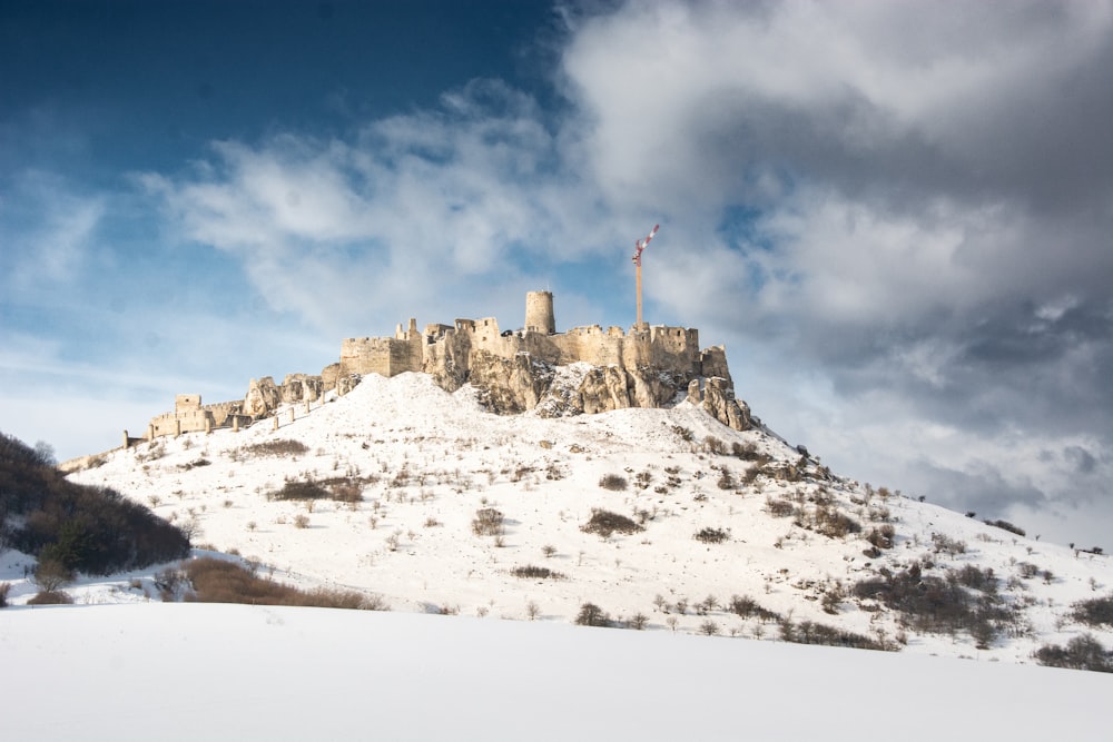 a snow covered mountain with a castle on top