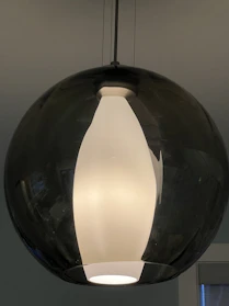 A sleek, modern pendant with clean lines and a minimalist design, glowing softly against a dark background.
