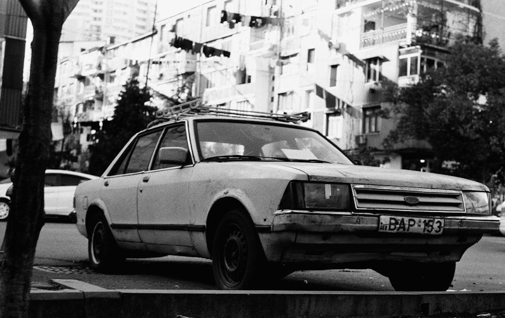 a black and white photo of a car parked on the side of the road