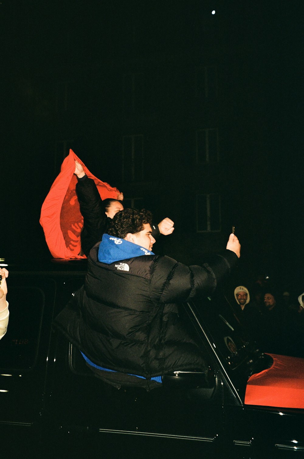 a man in a car waving a red flag