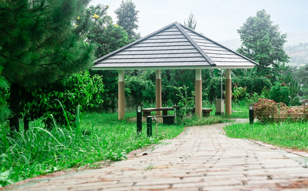a gazebo sitting in the middle of a lush green park