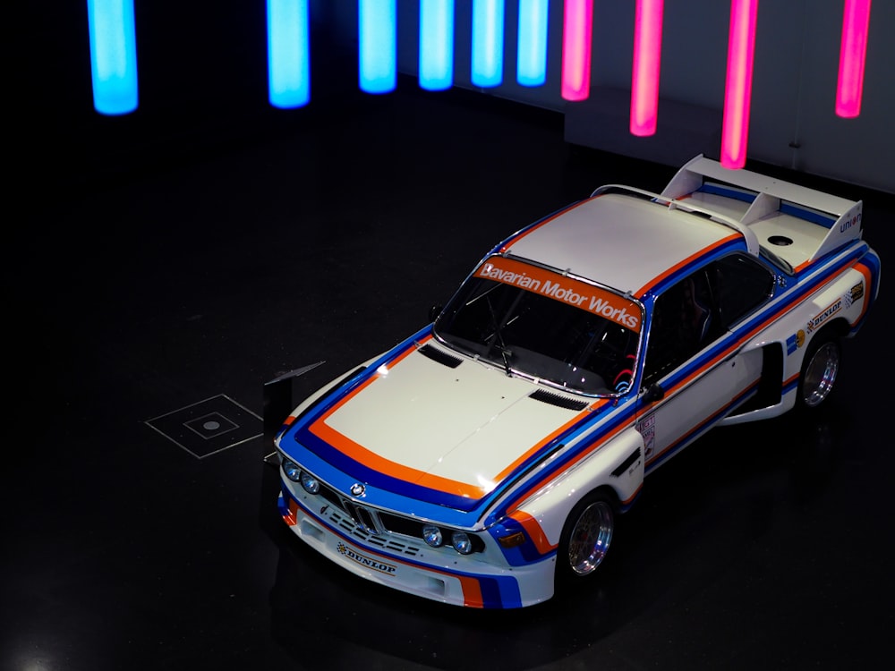a white and blue car with orange and blue stripes