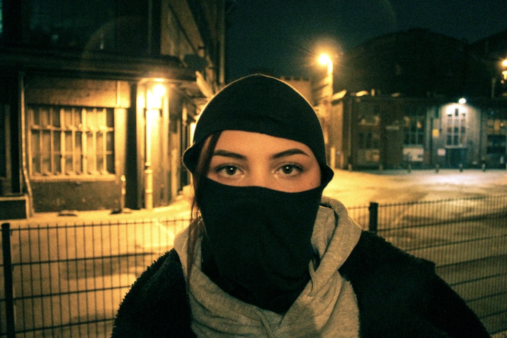 a woman wearing a black scarf and a black hat