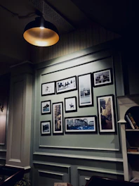 A cozy, dimly lit room with framed photographs hanging on the walls, symbolizing a private gallery.