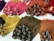Multiple bundles of hair in a variety of vibrant colors are neatly arranged on a white surface. The colors include pink, red, purple, yellow, and brown. Each bundle is tied securely and appears to be straight and smooth, with the strands lying parallel to one another.