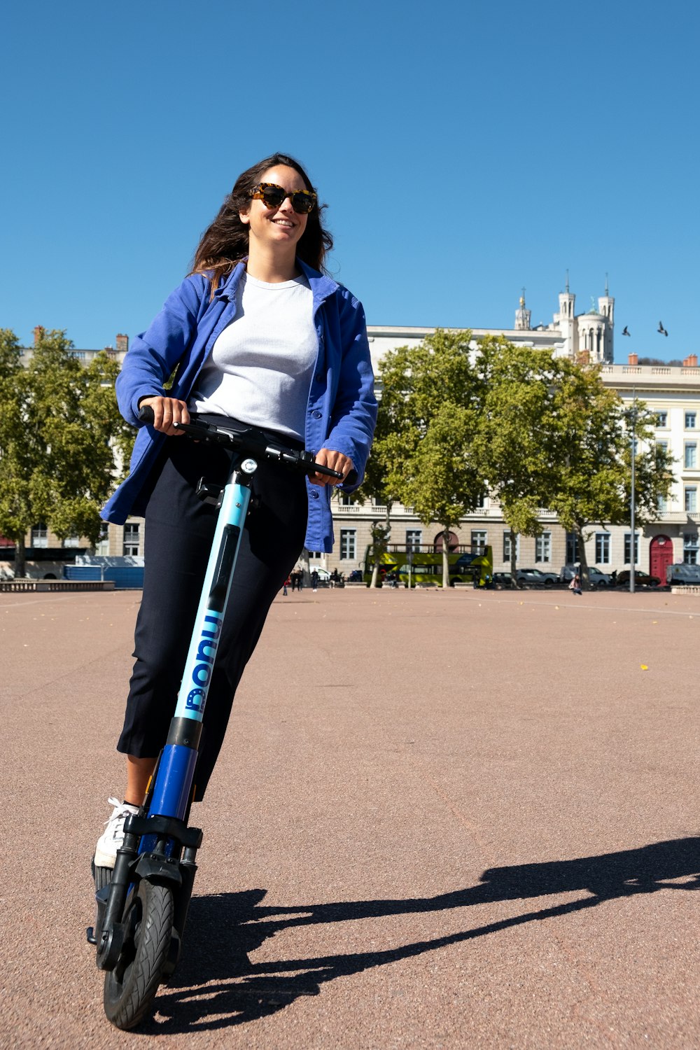 Una mujer montando un scooter en un estacionamiento