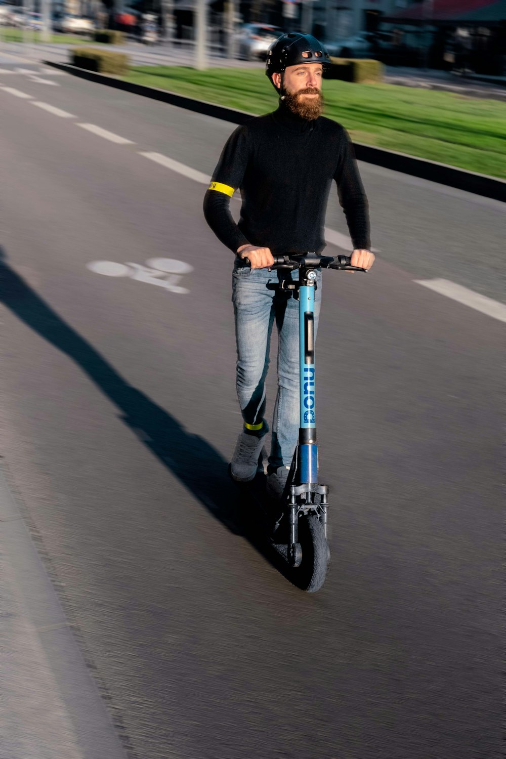 Un hombre montando un scooter por una calle