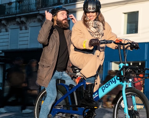 a man and a woman on a blue bicycle