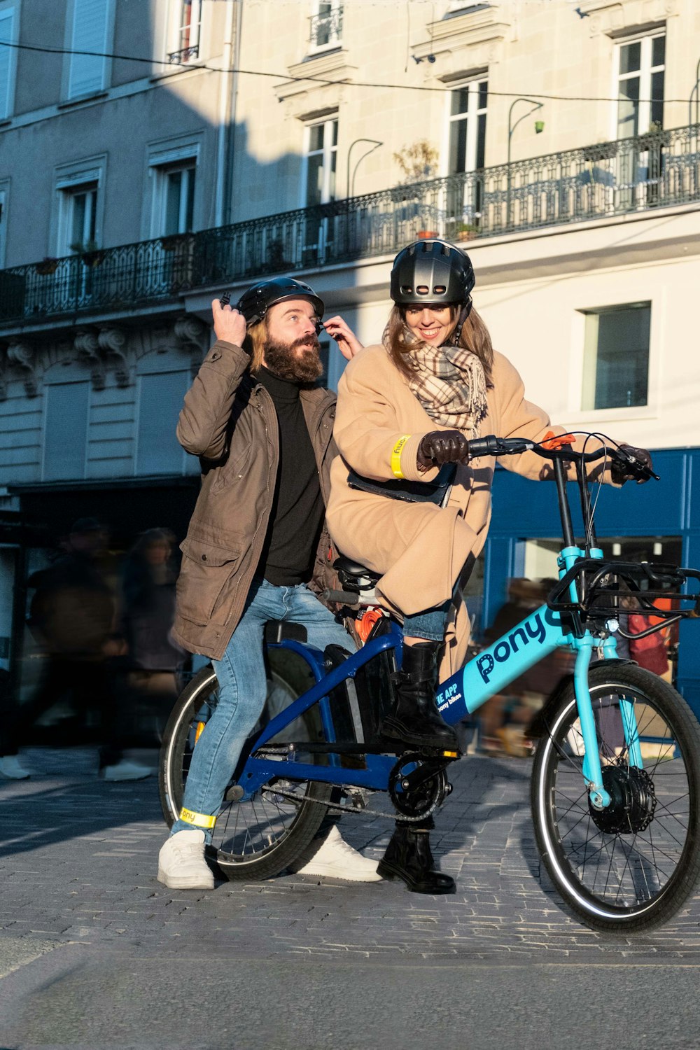 a man and a woman on a blue bicycle