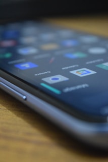 A close-up of a smartphone with a Whilix review displayed on the screen.