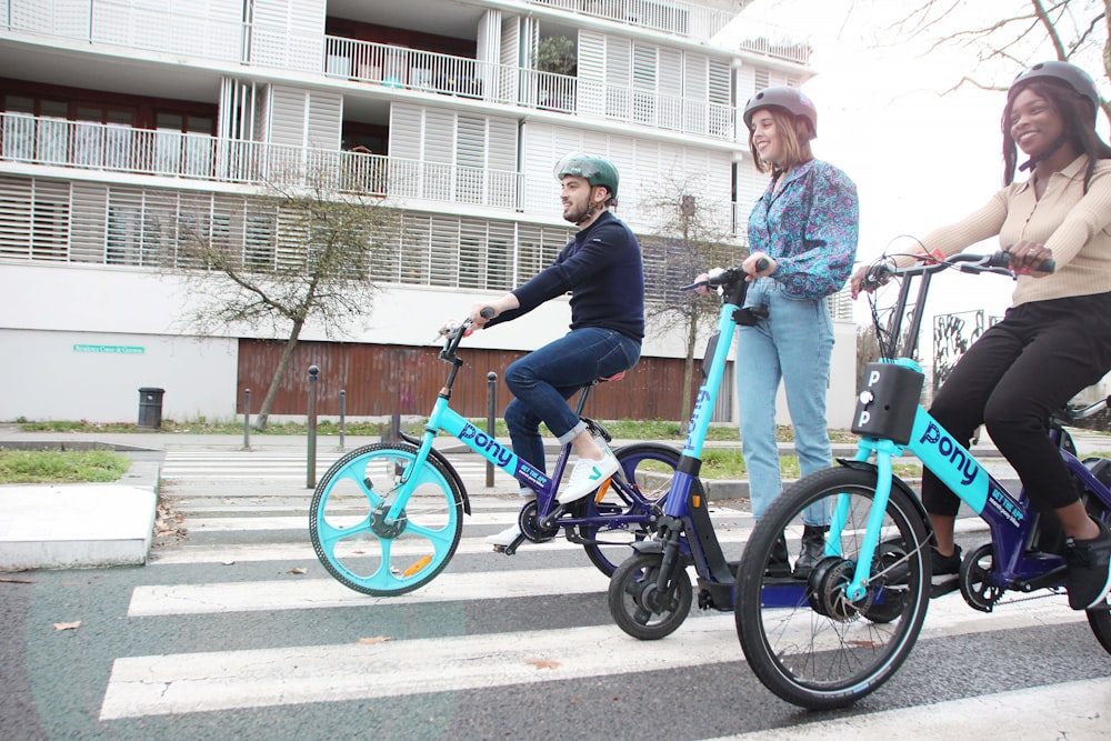 a couple of people riding bikes across a street