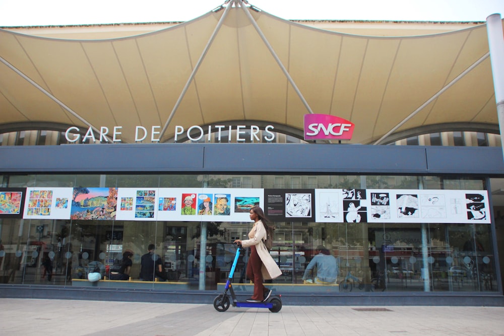 une personne conduisant un scooter devant un magasin