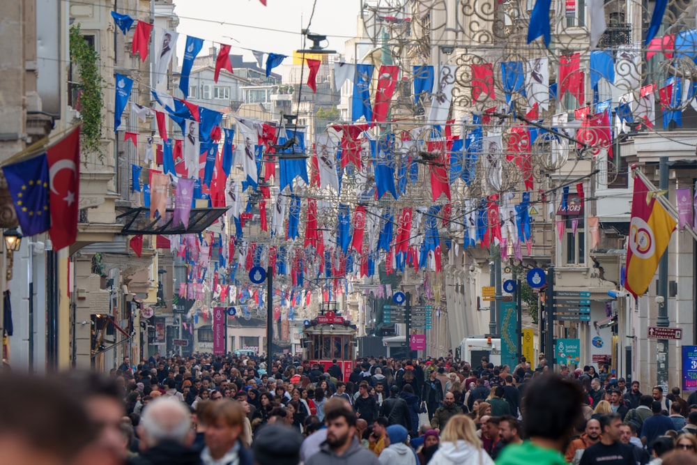 Una folla di persone che camminano lungo una strada accanto a edifici alti