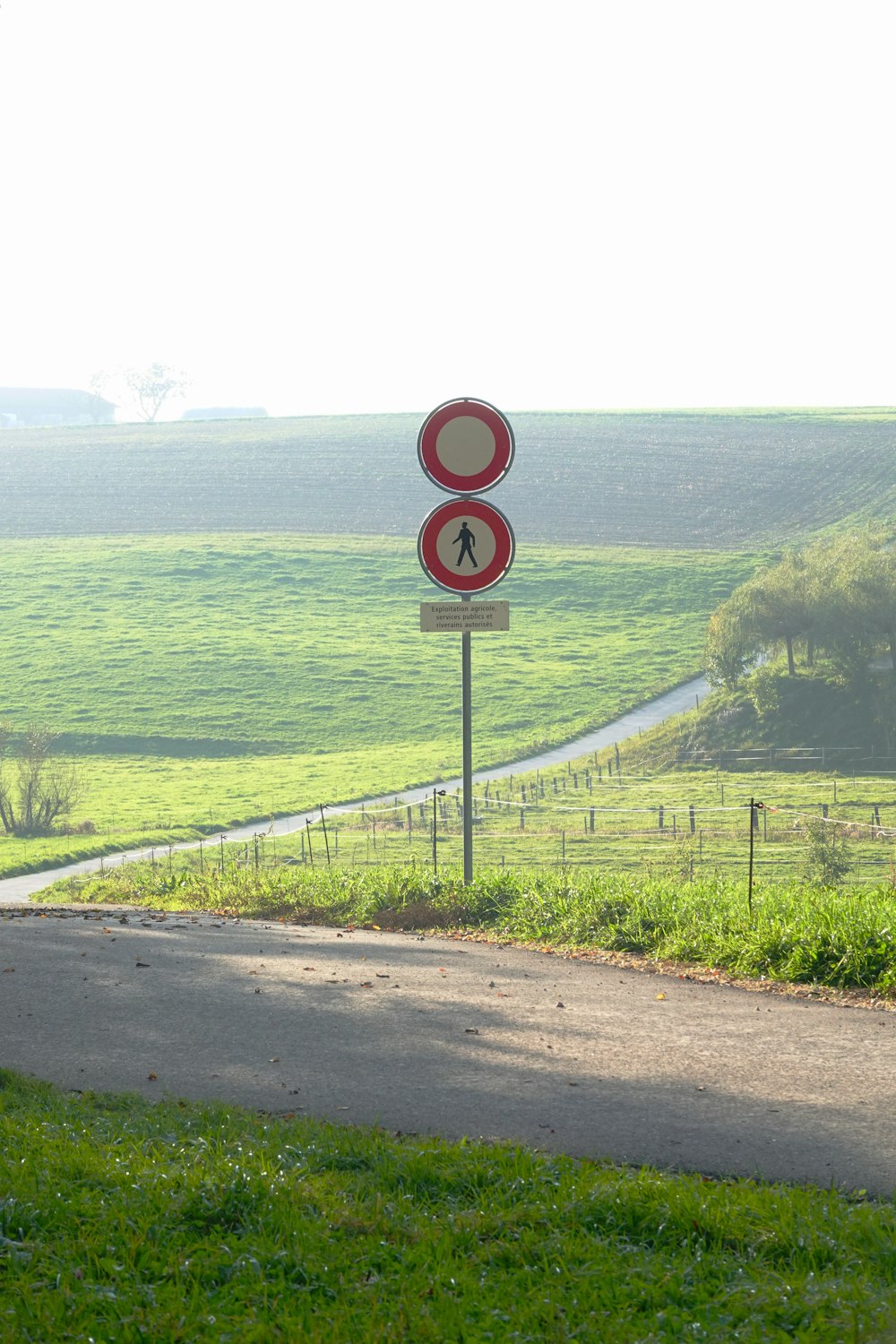  Un letrero rojo y blanco sentado al costado de una carretera