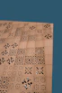 Close-up of a laser-engraved wooden decor piece resting on a natural linen cloth.