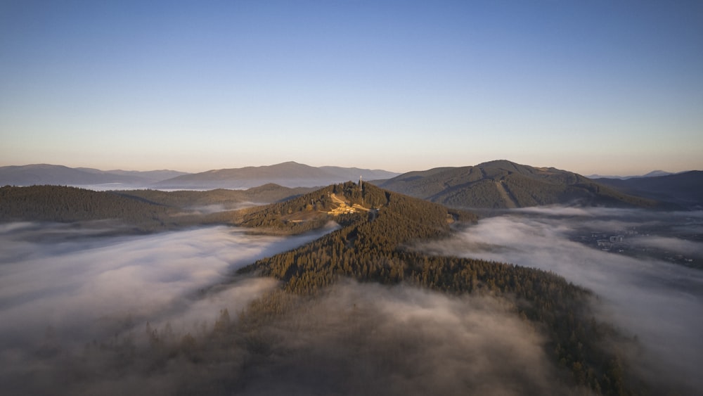 an aerial view of a mountain with low lying clouds