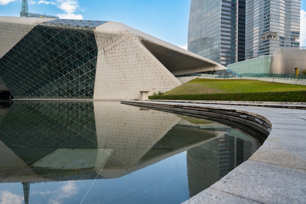 a large building with a large pool of water in front of it