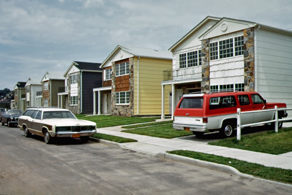 a row of houses with cars parked in front of them