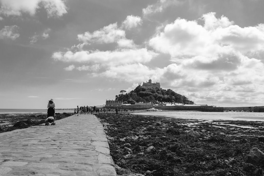 a black and white photo of a person walking a dog