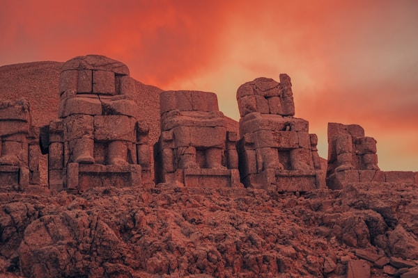 a group of stone statues sitting on top of a rocky hillside