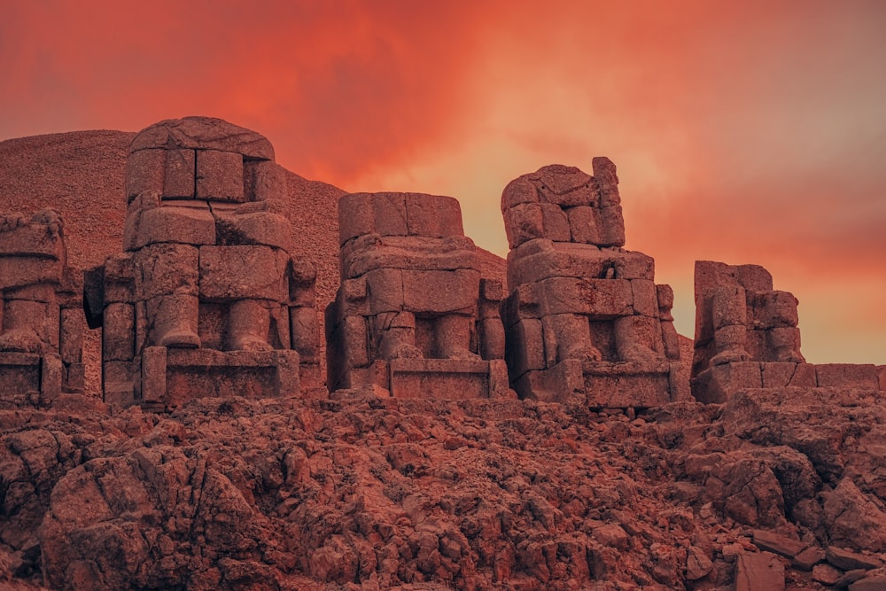 a group of stone statues sitting on top of a rocky hillside