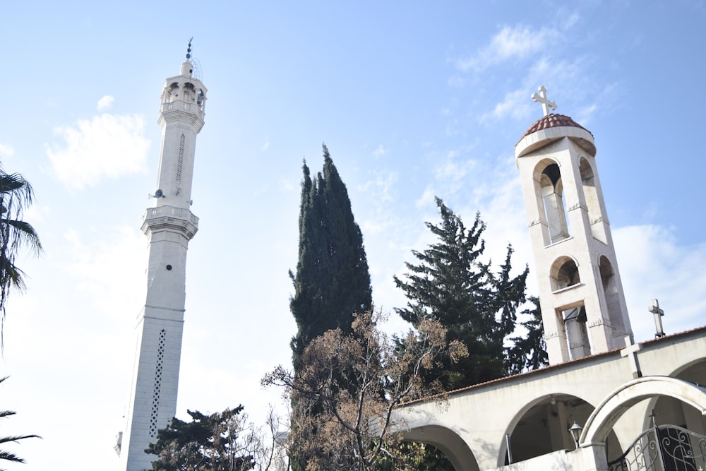 a tall white clock tower sitting next to a tall white building