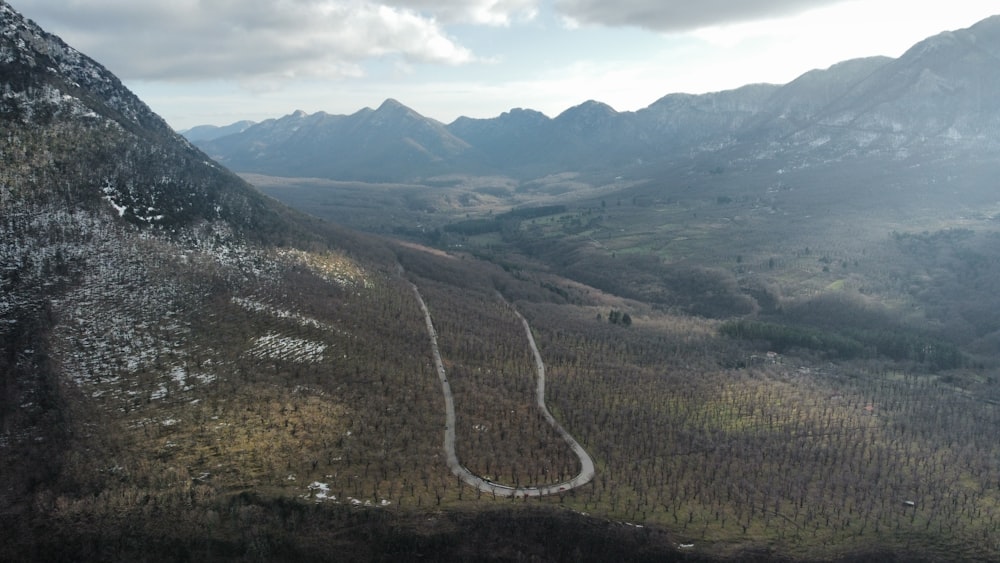 an aerial view of a winding road in the mountains