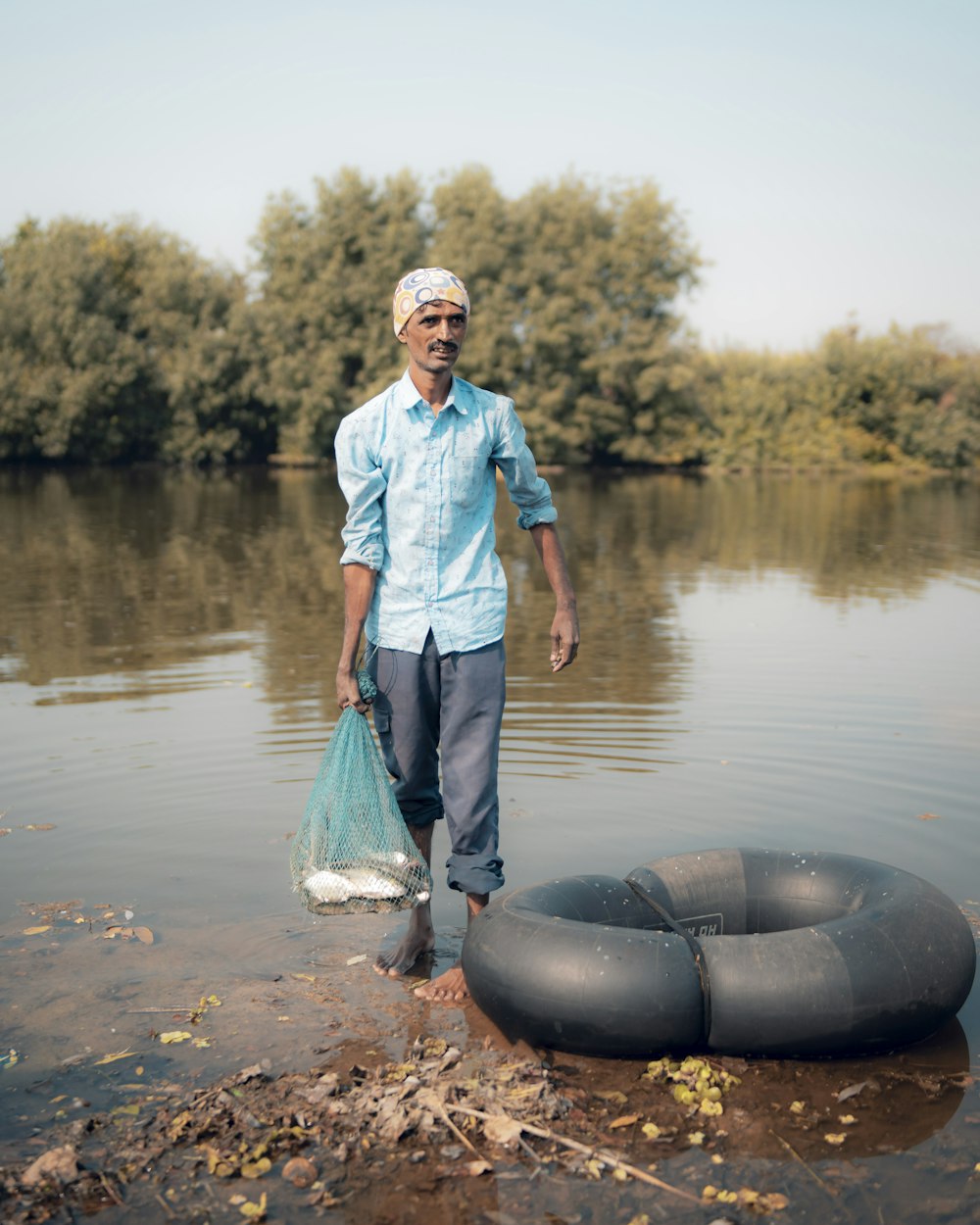 a man standing in a body of water with an inflatable raft