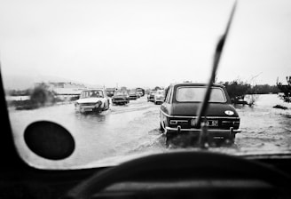 A team helping a stranded driver with a flooded vehicle at dusk.