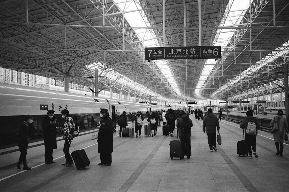 a black and white photo of people at a train station