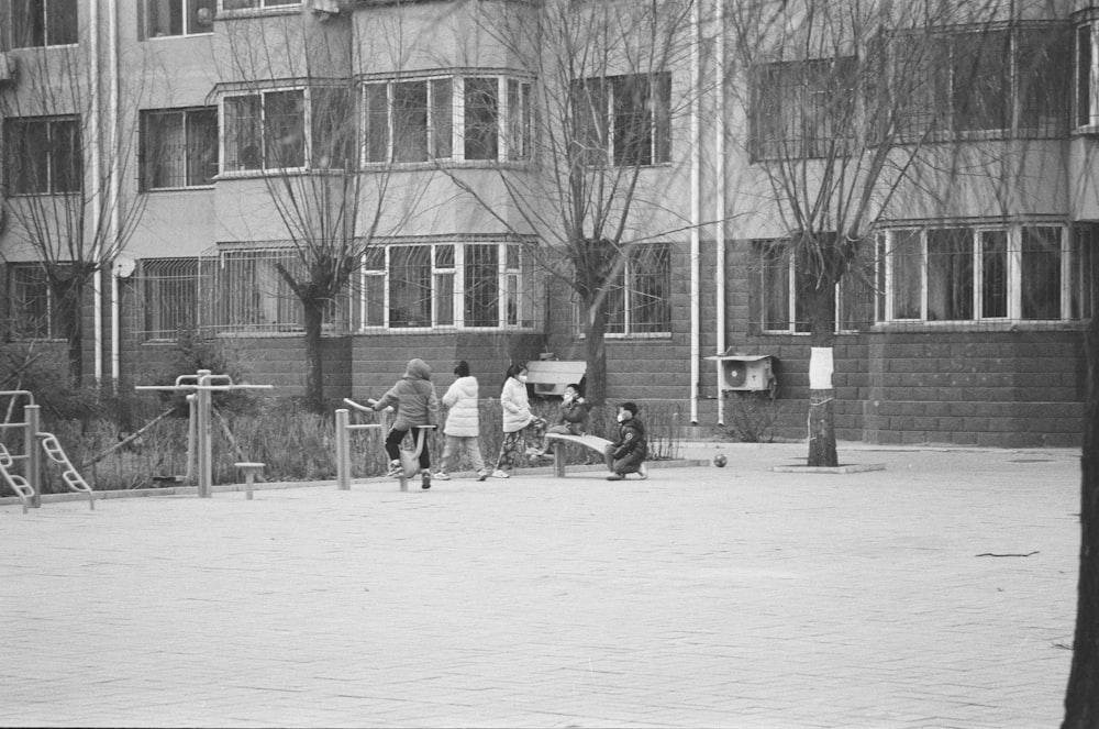 a black and white photo of a group of people playing basketball
