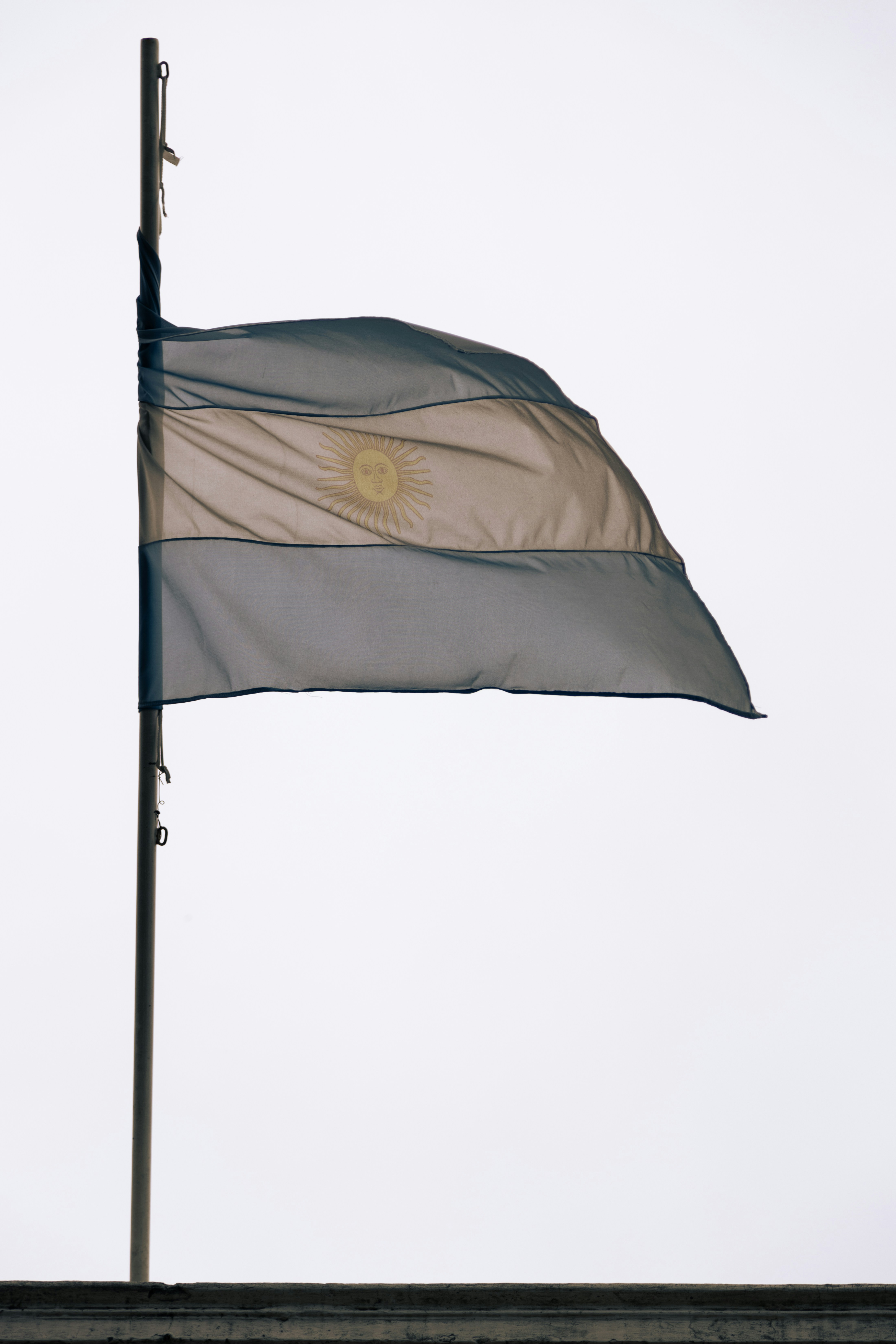 a flag flying in the wind on top of a building